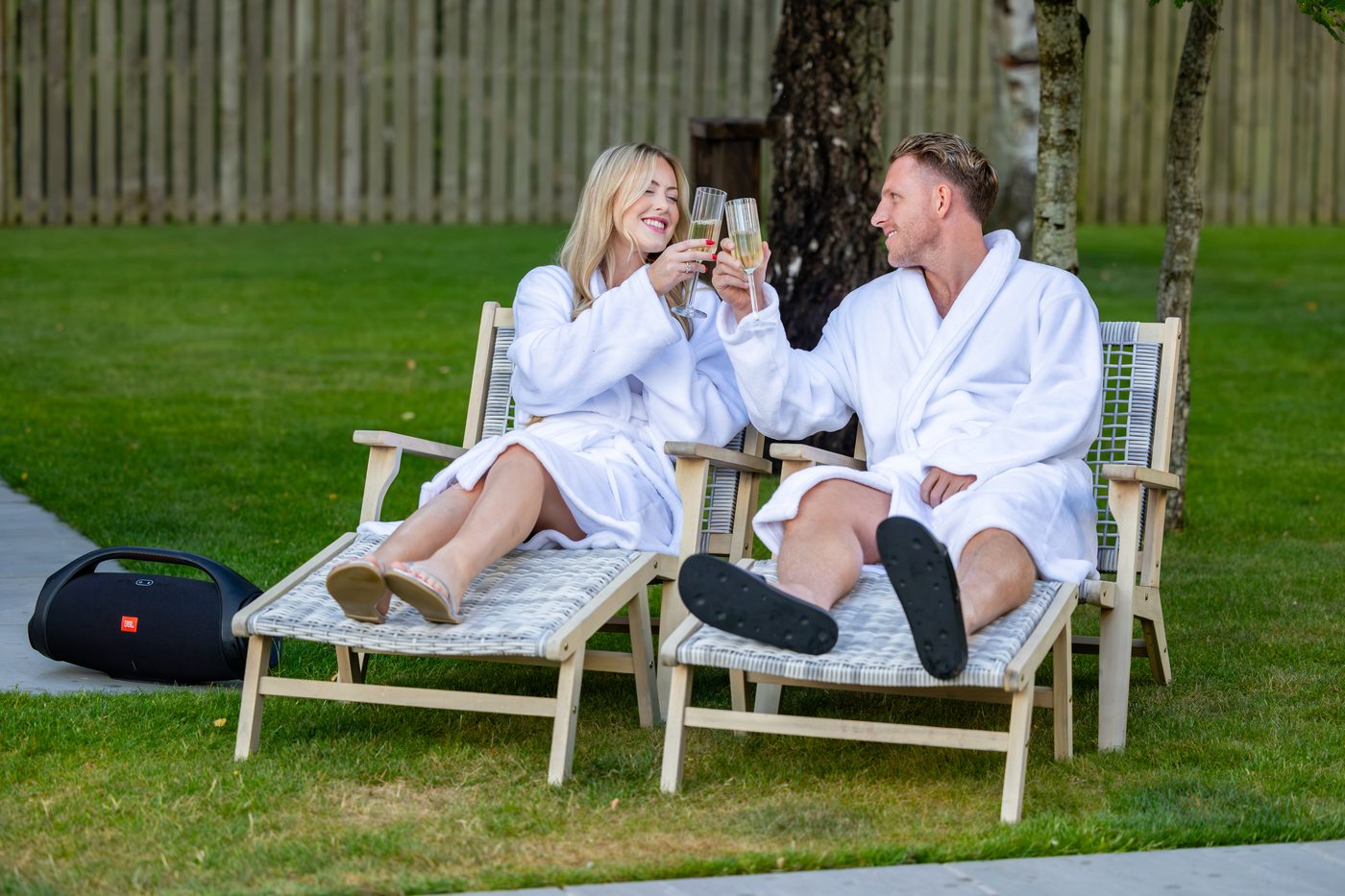 A couple in spa robes toasting on the sun loungers at Warren House