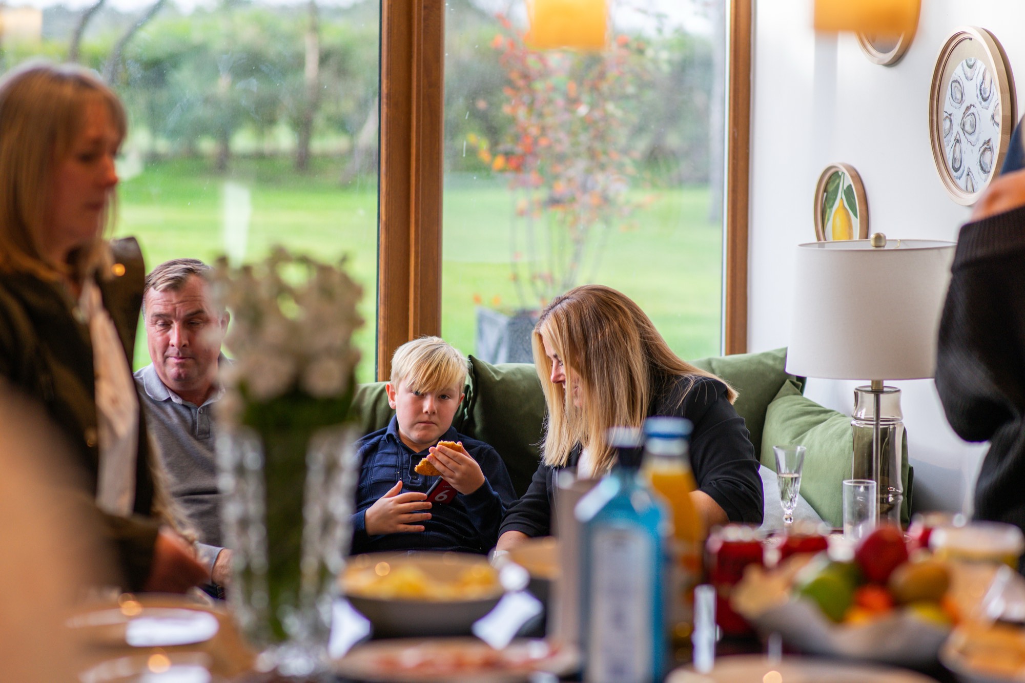 A family eating and laughing together at the dining table at Warren House